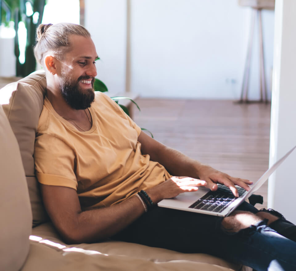 smiling-man-working-on-laptop-while-resting-on-sof-2023-11-27-05-21-29-utc 1 (2) (1)
